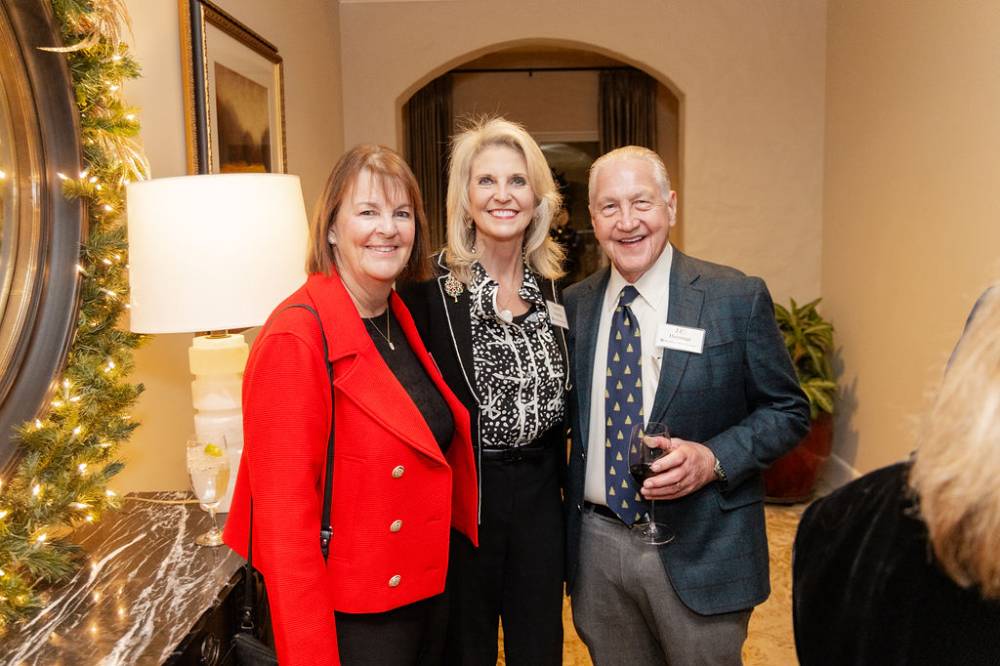 J.C. Huizenga and two other women attending party standing together and smiling at camera